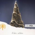 "Dubai erleben" Schrfitzug auf einem Poster für Dubai, im Hintergrund ein Hotel und eine Palme.